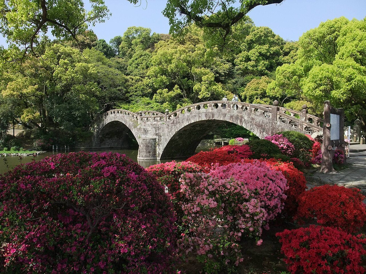 花と木々の間に二連のアーチが見える諫早眼鏡橋